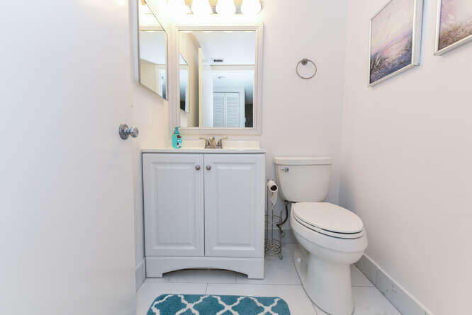 1605 Highway 1, Unit B105 Jupiter, FL 33477 - Photo 24 of 30 a bathroom with a sink a toilet and mirror