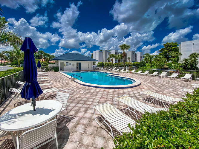 1605 Highway 1, Unit B105 Jupiter, FL 33477 - Photo 29 of 30 a swimming pool with barbeque oven outdoor seating and yard