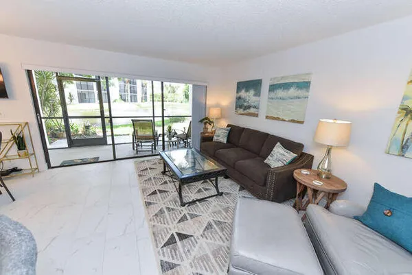 a living room with furniture and a floor to ceiling window