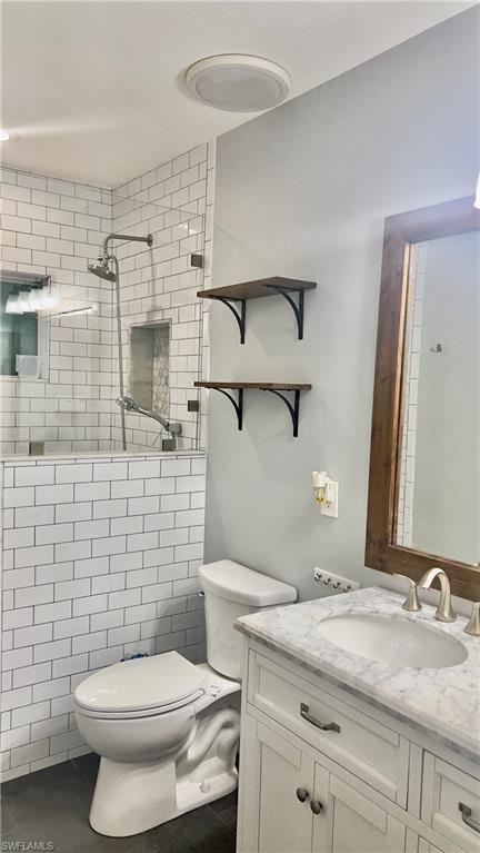 19550 Bowring Park Road, Unit 103 Fort Myers, FL 33967 - Photo 17 of 22 a bathroom with a granite countertop toilet sink and a mirror