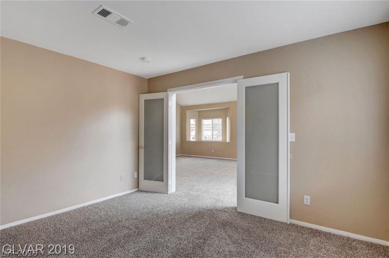2647 Ridgewater Circle Henderson, NV 89074 - Photo 11 of 26 Double frosted glass doors open to reveal versatile interior spaces finished with wall-to-wall carpeting.
