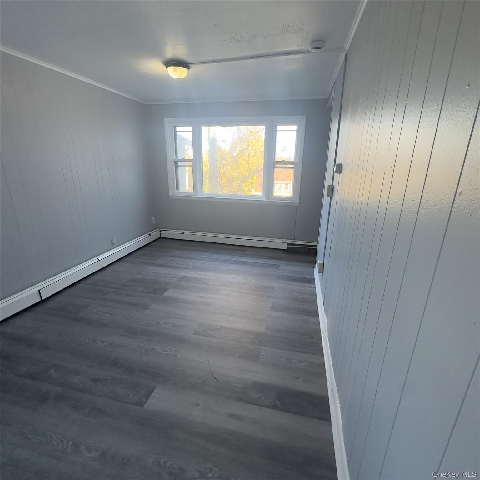 26 Du Bois Avenue, Unit 2 Poughkeepsie, NY 12601 - Photo 2 of 9 an empty room with wooden floor and windows