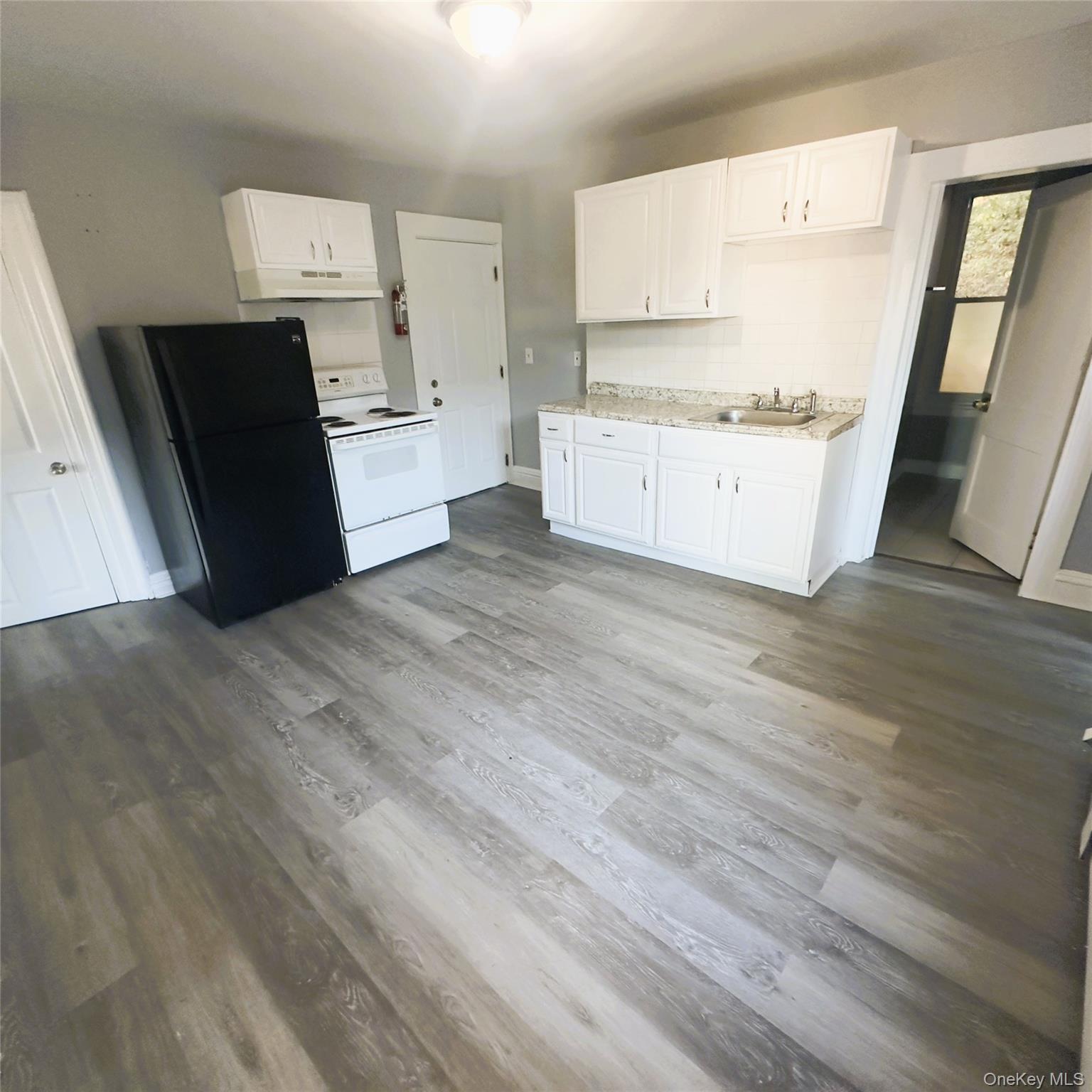 26 Du Bois Avenue, Unit 2 Poughkeepsie, NY 12601 - Photo 3 of 9 a kitchen with white cabinets and black appliances
