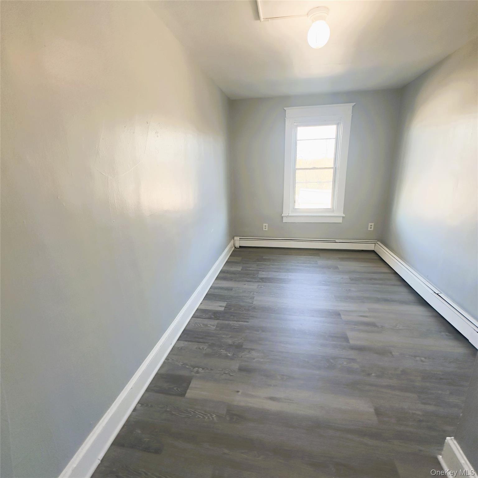 26 Du Bois Avenue, Unit 2 Poughkeepsie, NY 12601 - Photo 5 of 9 an empty room with wooden floor and windows