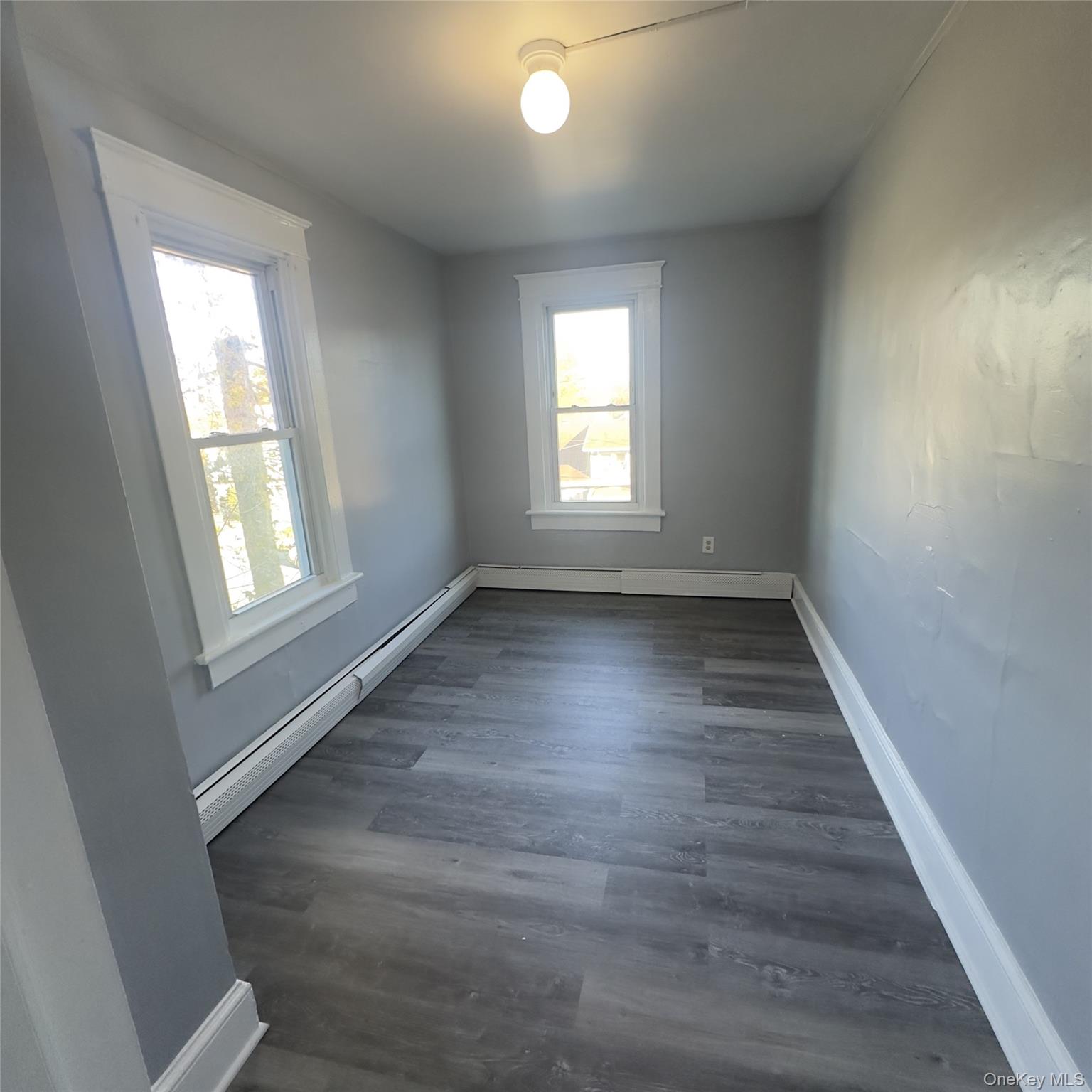 26 Du Bois Avenue, Unit 2 Poughkeepsie, NY 12601 - Photo 6 of 9 an empty room with wooden floor and windows
