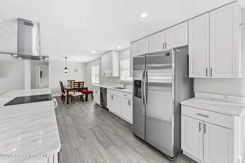a kitchen with kitchen island white cabinets and stainless steel appliances