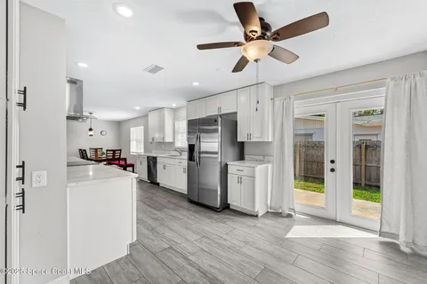 a kitchen with refrigerator a microwave and white cabinets