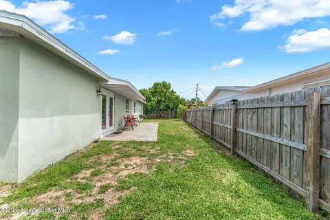 a view of a backyard with wooden fence