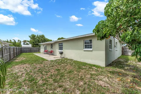 a view of backyard of house with wooden fence