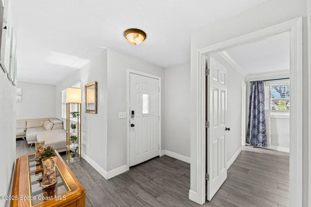 a view of a hallway with wooden floor and closet