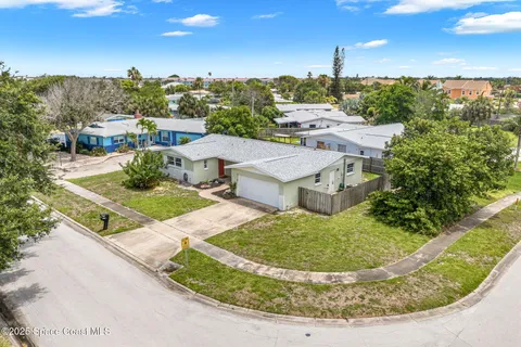 a front view of a house with a yard and potted plants