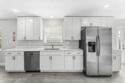 a kitchen with a refrigerator sink and cabinets