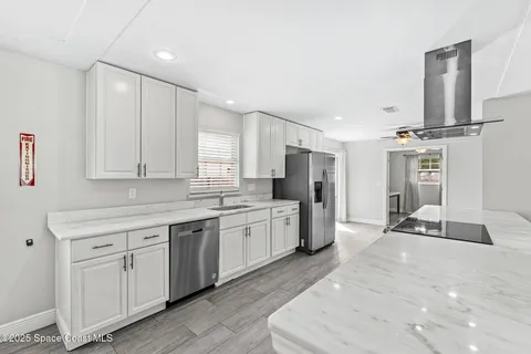 a large white kitchen with cabinets appliances and a sink
