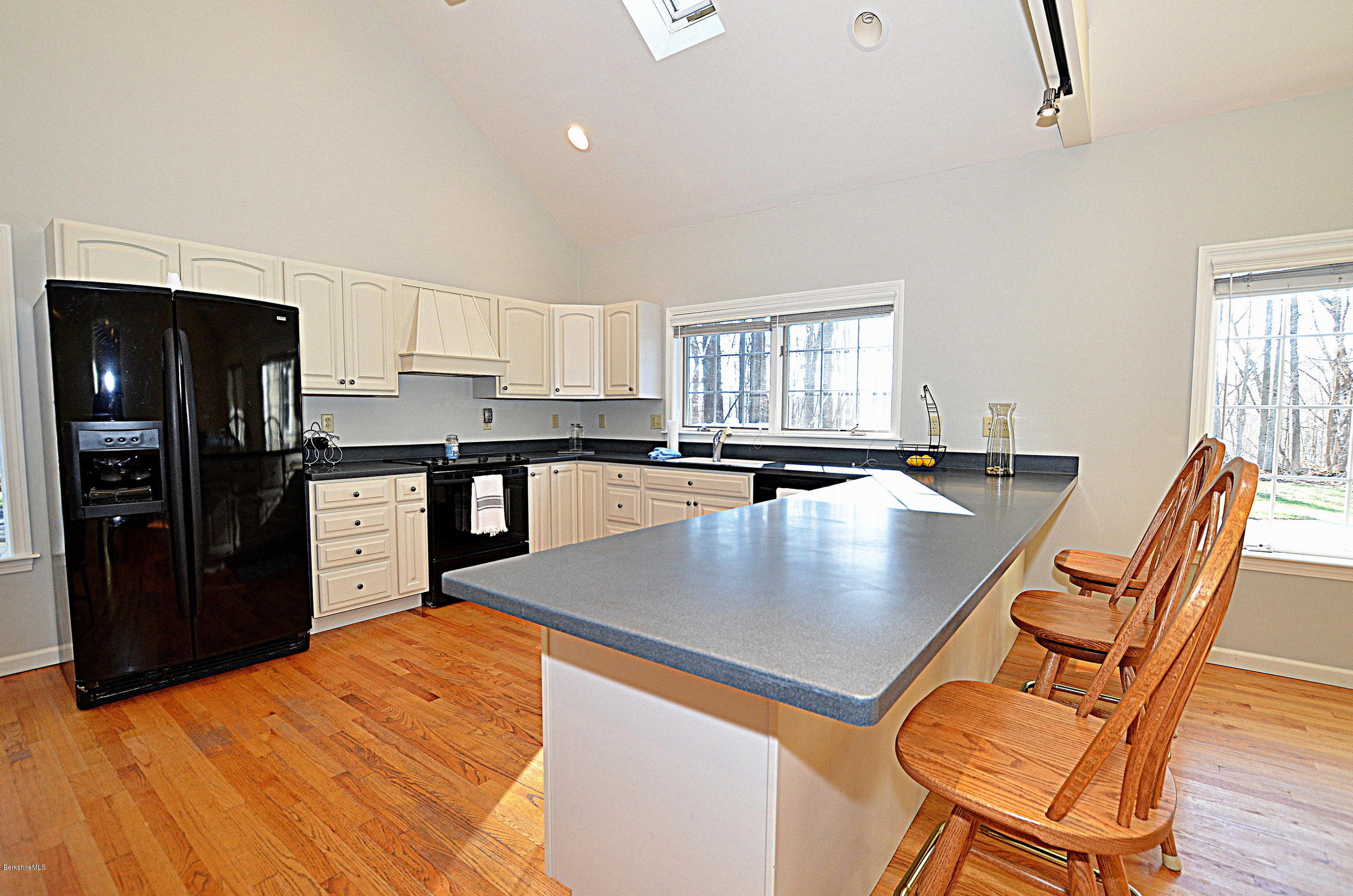 2307 Jacobs Ladder Road Becket, MA 01223 - Photo 12 of 55 a large kitchen with stainless steel appliances granite countertop a stove a refrigerator a sink a dining table and chairs