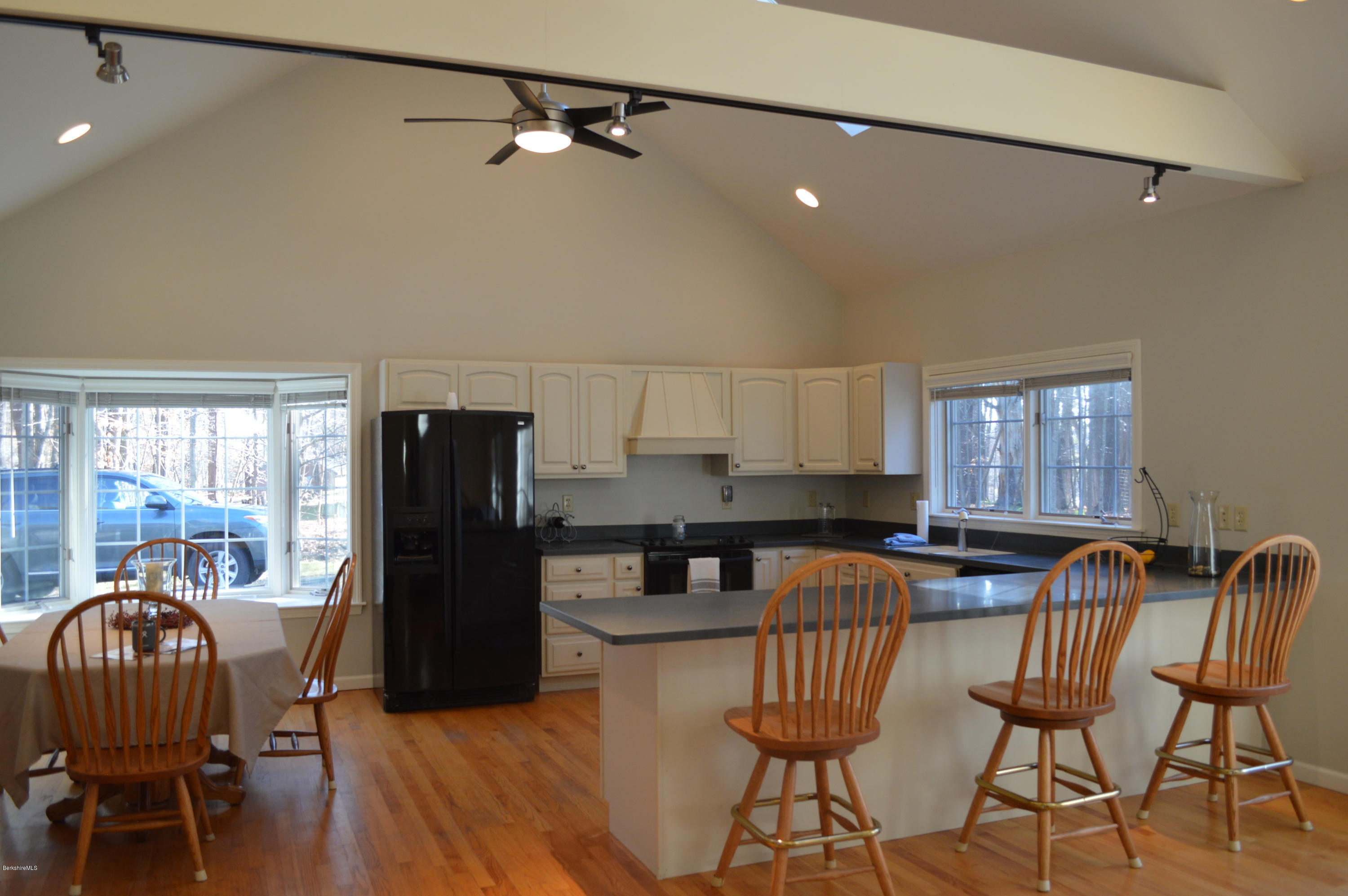 2307 Jacobs Ladder Road Becket, MA 01223 - Photo 13 of 55 a kitchen with stainless steel appliances granite countertop a dining table chairs a refrigerator and a window