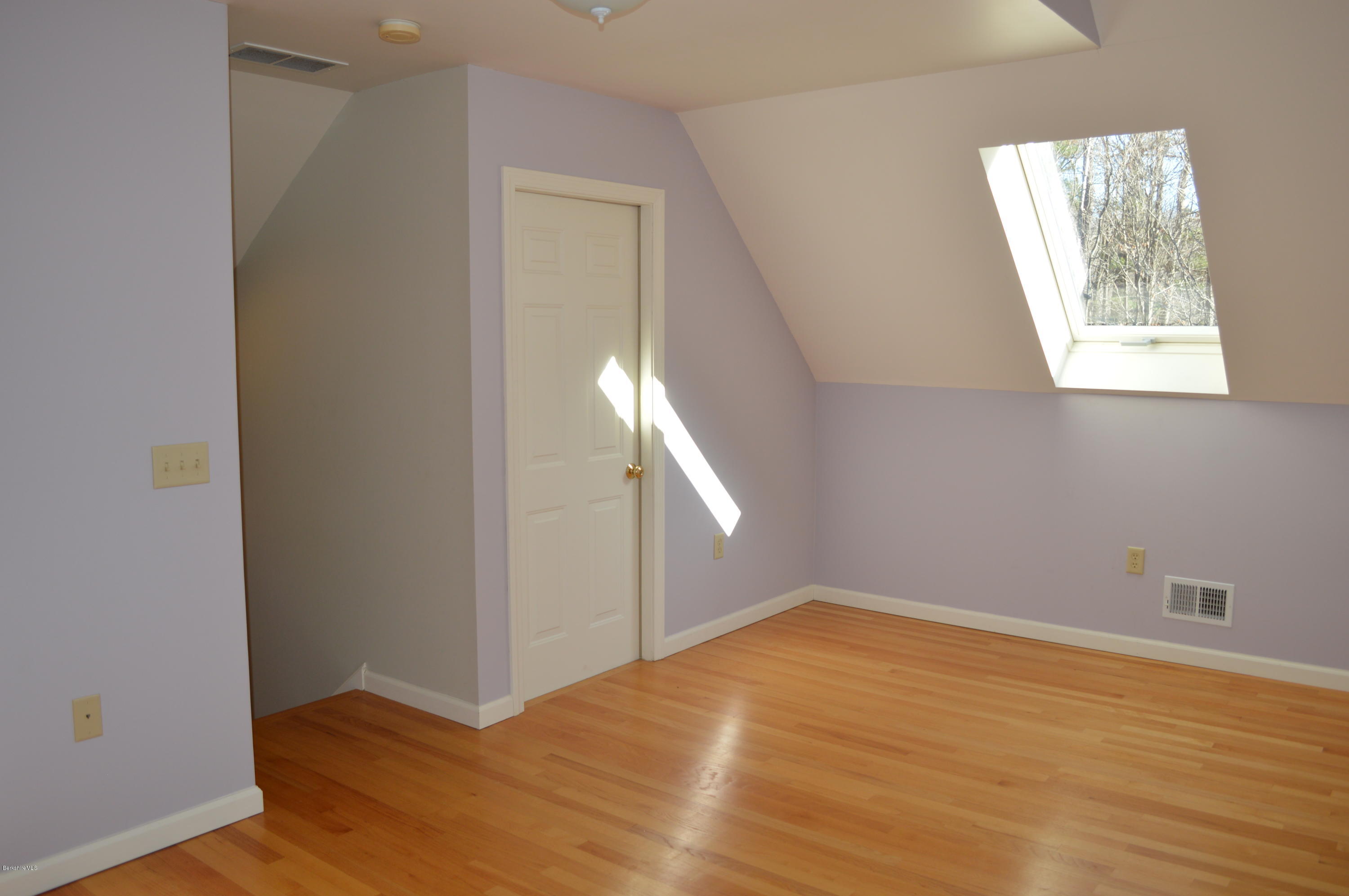 2307 Jacobs Ladder Road Becket, MA 01223 - Photo 39 of 55 an empty room with wooden floor cabinet and windows