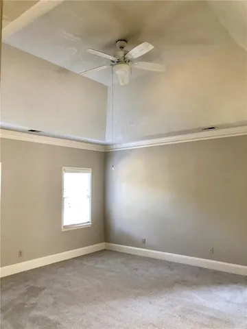 an empty room with a window and a ceiling fan