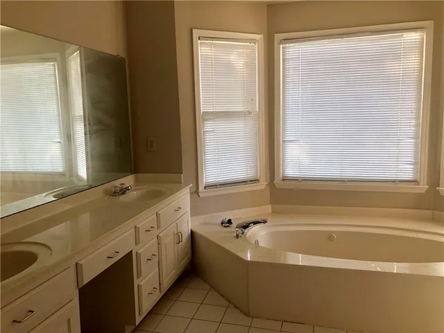 a bathroom with a bathtub and next to a window
