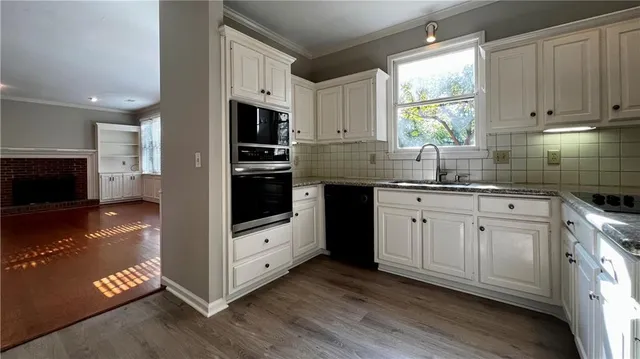 a kitchen with stainless steel appliances granite countertop a stove a sink and a microwave