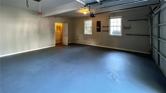 an empty room with windows and ceiling fan
