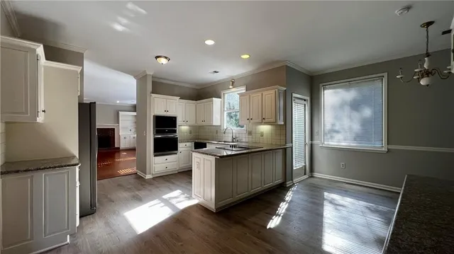 a kitchen with stainless steel appliances granite countertop a refrigerator and a stove top oven