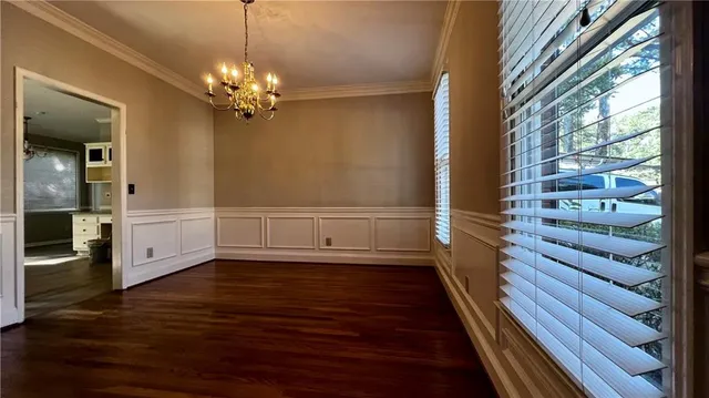 a view of a room with wooden floors and chandelier