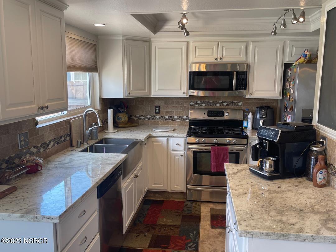 1108 Honeysuckle Way Lompoc, CA 93436 - Photo 19 of 54 a kitchen with stainless steel appliances granite countertop a stove top oven a sink a counter space and cabinets