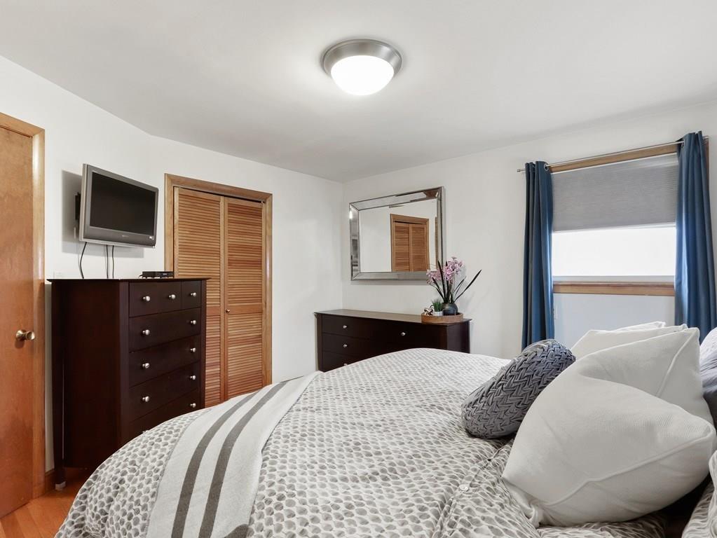 66 Anthony Road Newton, MA 02460 - Photo 18 of 39 a bedroom with a large bed and a flat tv screen on dresser