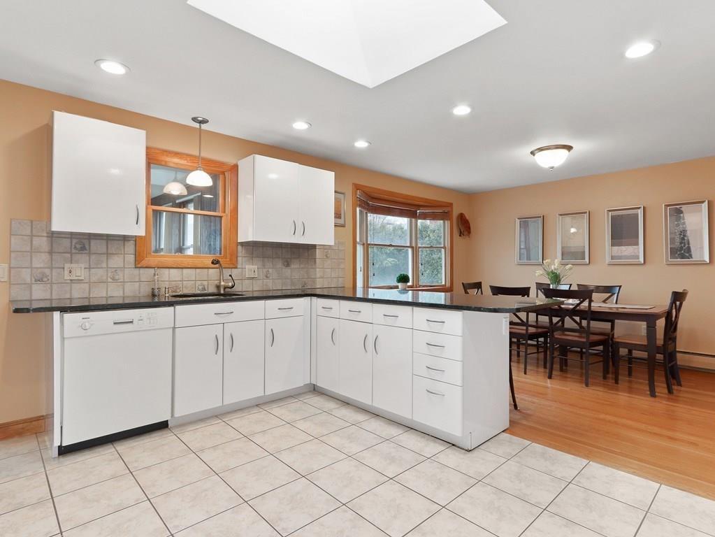66 Anthony Road Newton, MA 02460 - Photo 10 of 39 a large white kitchen with cabinets chairs and granite counter tops