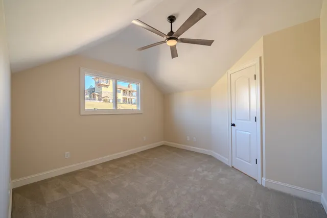 a view of an empty room with a ceiling fan and a window