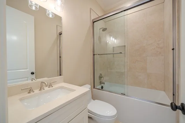a bathroom with a bathtub shower sink vanity and toilet