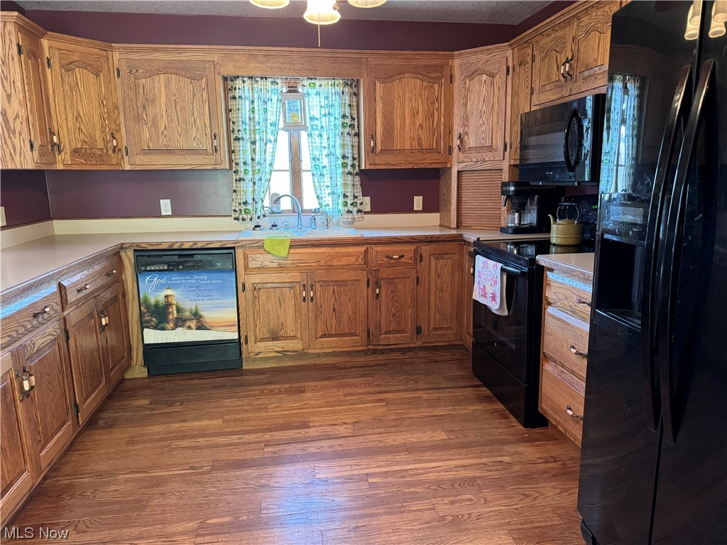 2812 Tabor Ridge Road Northeast Mineral City, OH 44656 - Photo 8 of 23 Kitchen with black appliances, sink, and dark wood-type flooring