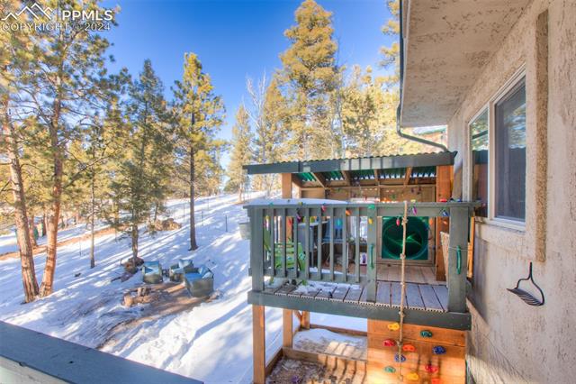 31 Wahsatch Road Florissant, CO 80816 - Photo 41 of 46 Custom playhouse has Trex decking, a slide, sandbox, rope and climbing wall