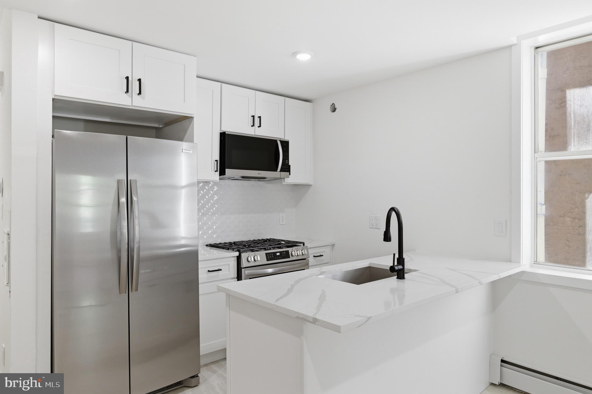 5939 Drexel Road, Unit CARRIAGE Philadelphia, PA 19131 - Photo 11 of 20 a kitchen with stainless steel appliances a refrigerator a sink a stove and cabinets