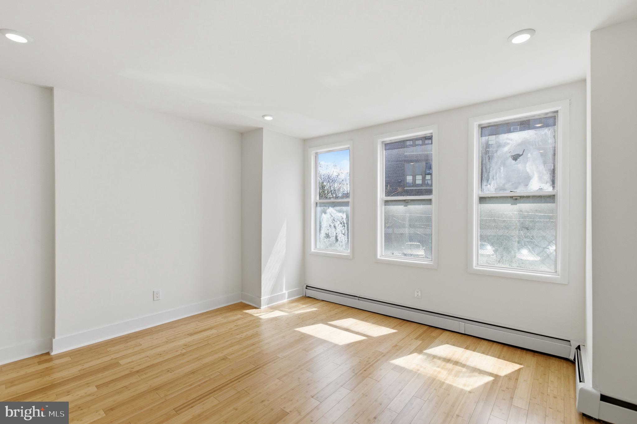 5939 Drexel Road, Unit CARRIAGE Philadelphia, PA 19131 - Photo 18 of 20 an empty room with wooden floor and windows