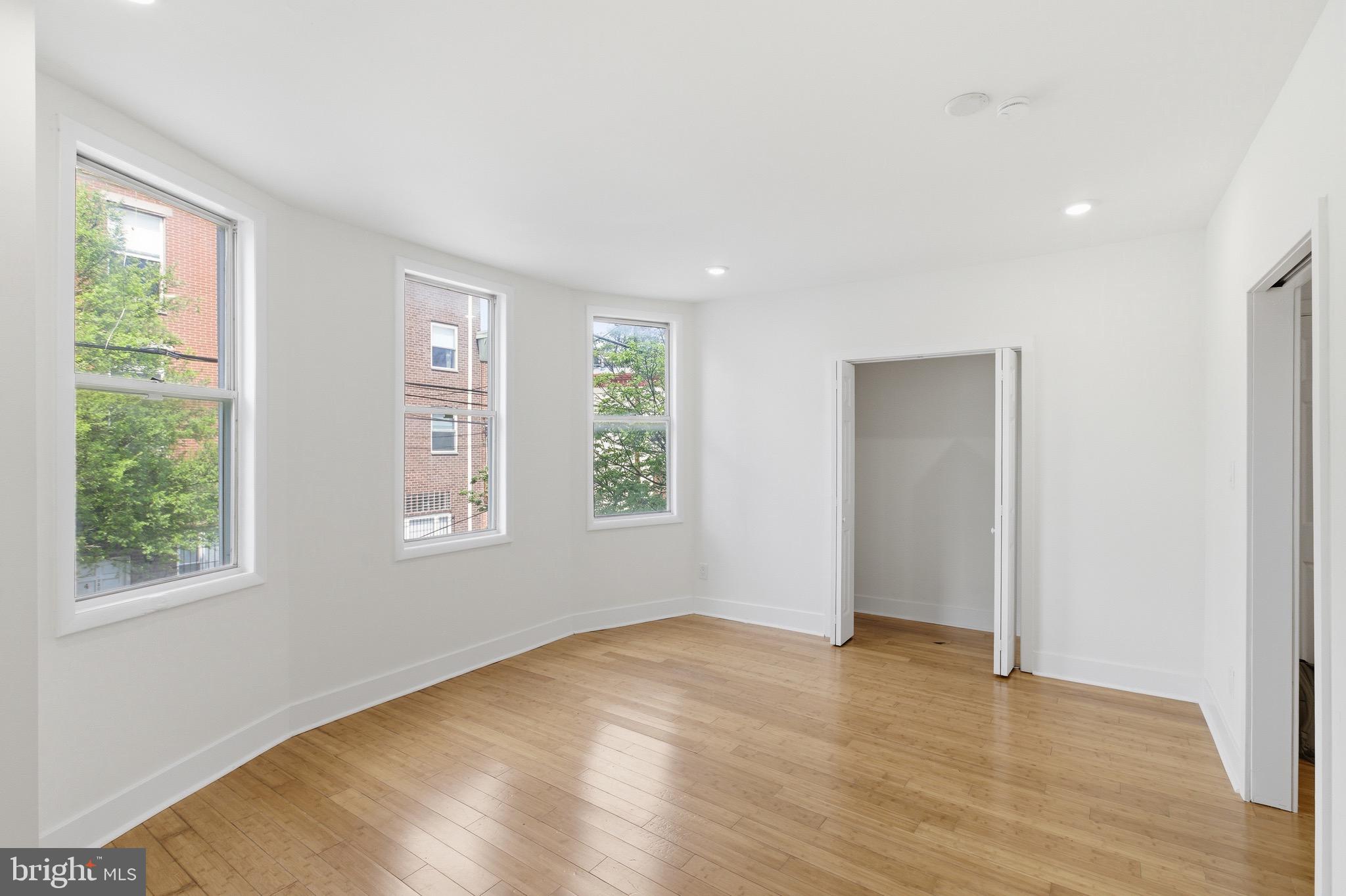 5939 Drexel Road, Unit CARRIAGE Philadelphia, PA 19131 - Photo 3 of 20 a view of empty room with wooden floor and fan