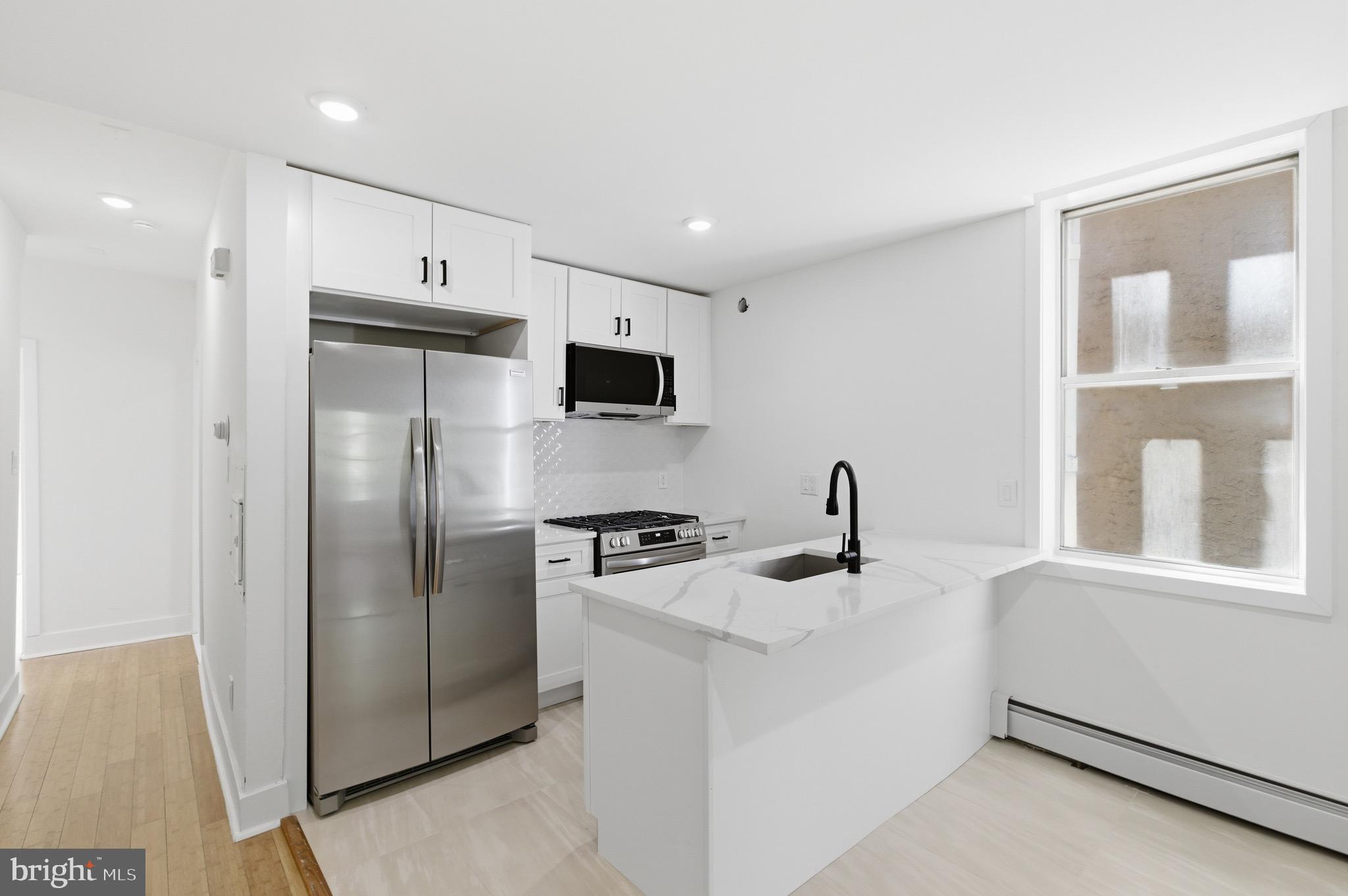 5939 Drexel Road, Unit CARRIAGE Philadelphia, PA 19131 - Photo 10 of 20 a kitchen with stainless steel appliances a refrigerator sink and microwave