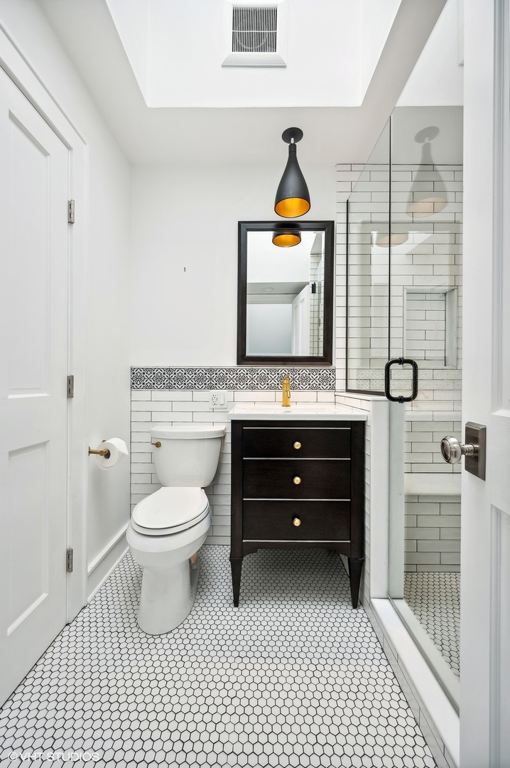 786 Locust Street Winnetka, IL 60093 - Photo 24 of 46 a bathroom with a toilet a sink and glass door