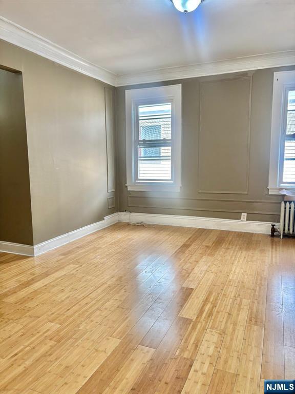 187 Shephard Avenue, Unit 1 Newark, NJ 07112 - Photo 13 of 18 an empty room with wooden floor and windows