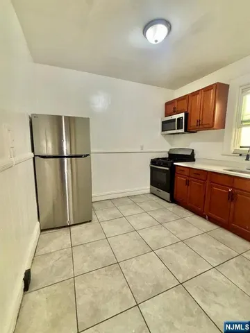 a kitchen with stainless steel appliances granite countertop a refrigerator sink and stove