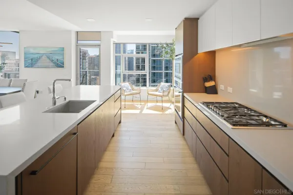 a large kitchen with kitchen island a large counter space a sink a stove and a window