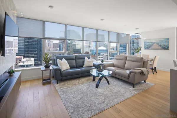 a view of a living room with a floor to ceiling window and wooden floor