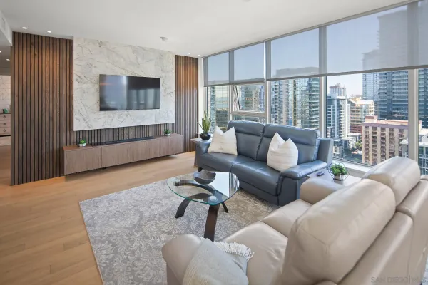 a living room with stainless steel appliances kitchen island granite countertop furniture and a large window