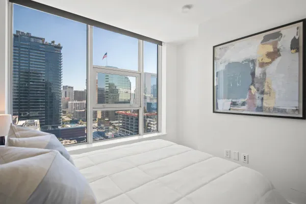 a bedroom with a bed and a lamp on dresser