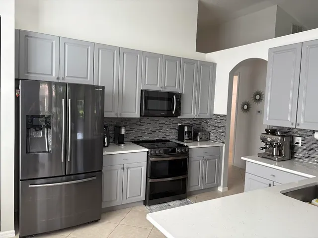 a kitchen with stainless steel appliances granite countertop a refrigerator stove and sink