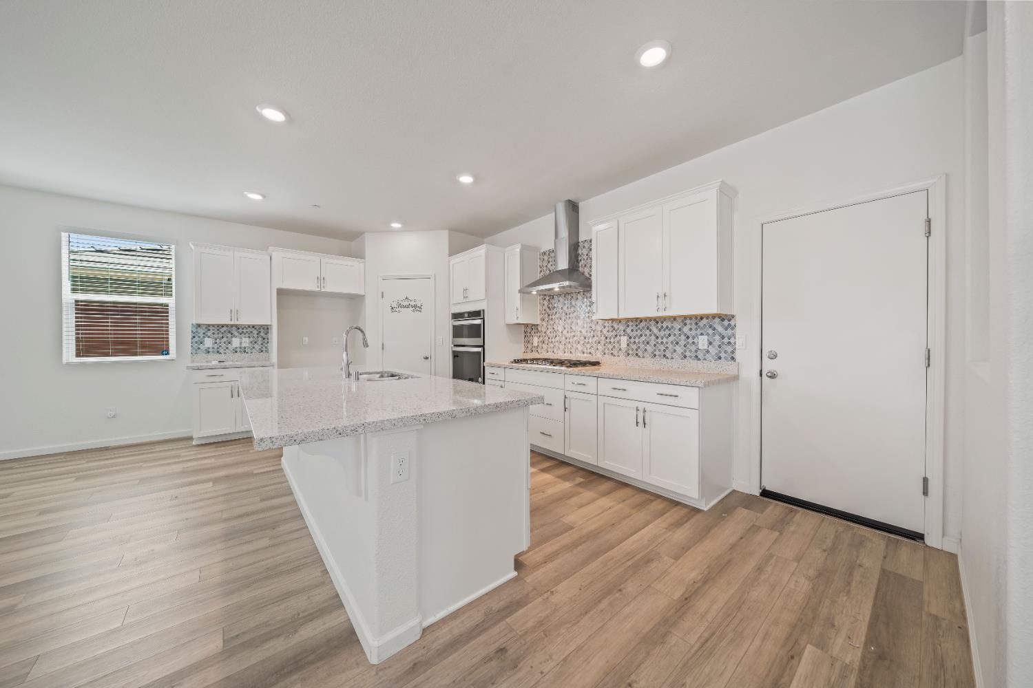 1602 Oleander Avenue Manteca, CA 95337 - Photo 13 of 52 a kitchen with stainless steel appliances white cabinets large wooden floor and a window