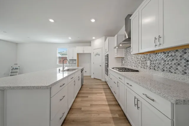 a large kitchen with granite countertop a sink and cabinets