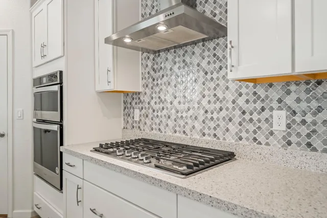 a stove top oven sitting inside of a kitchen