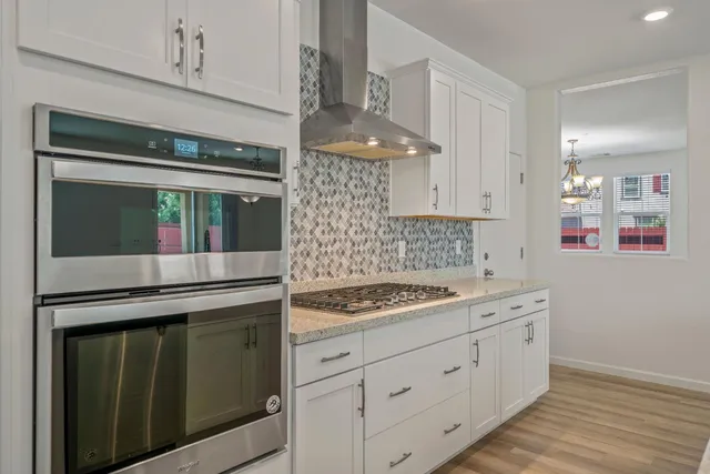a kitchen with stainless steel appliances granite countertop a sink stove and cabinets