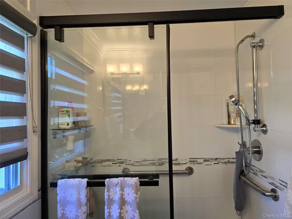 a bathroom with a granite countertop sink a mirror and shower
